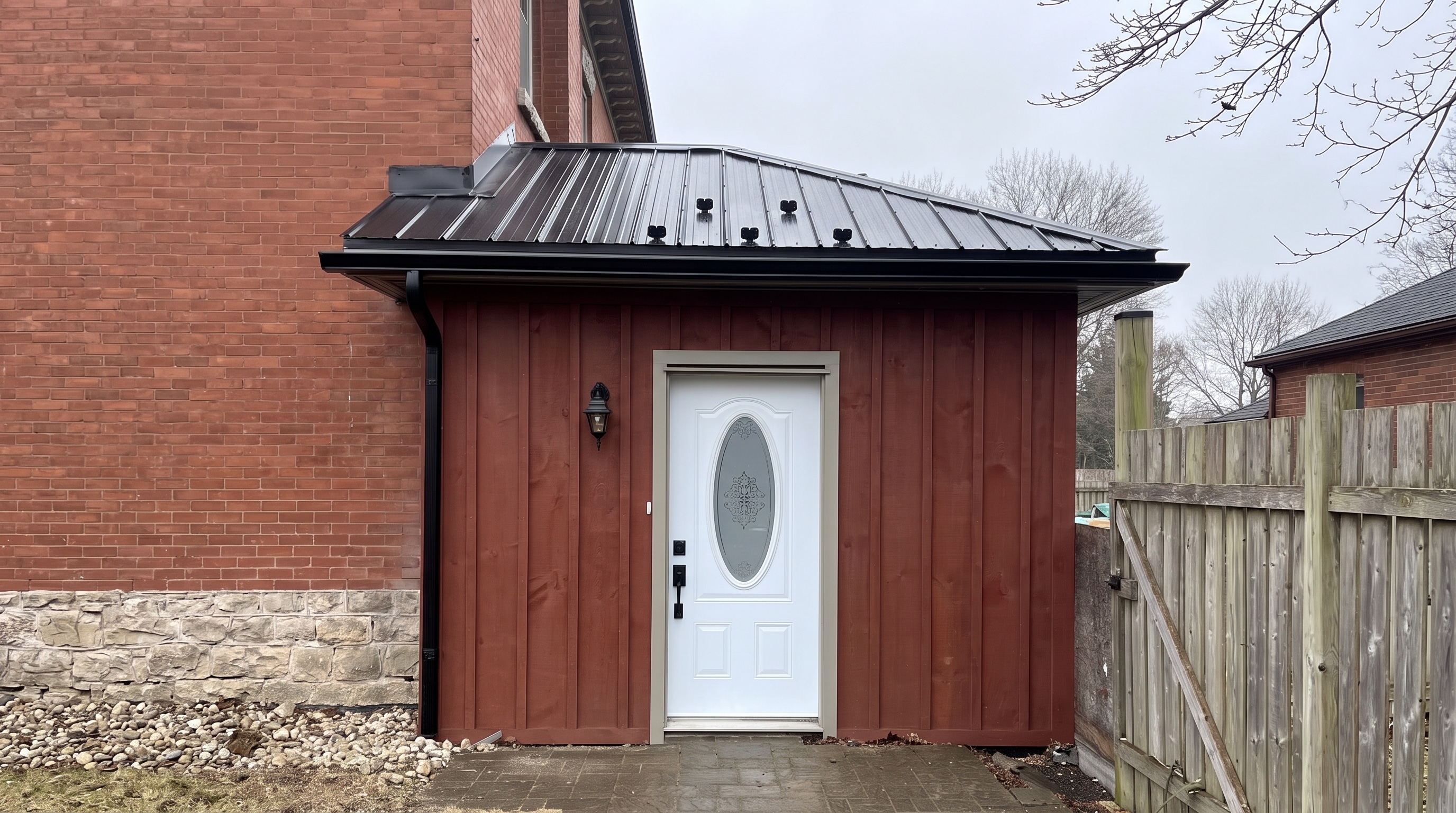 Board-and-batten entrance addition with standing-seam metal roof