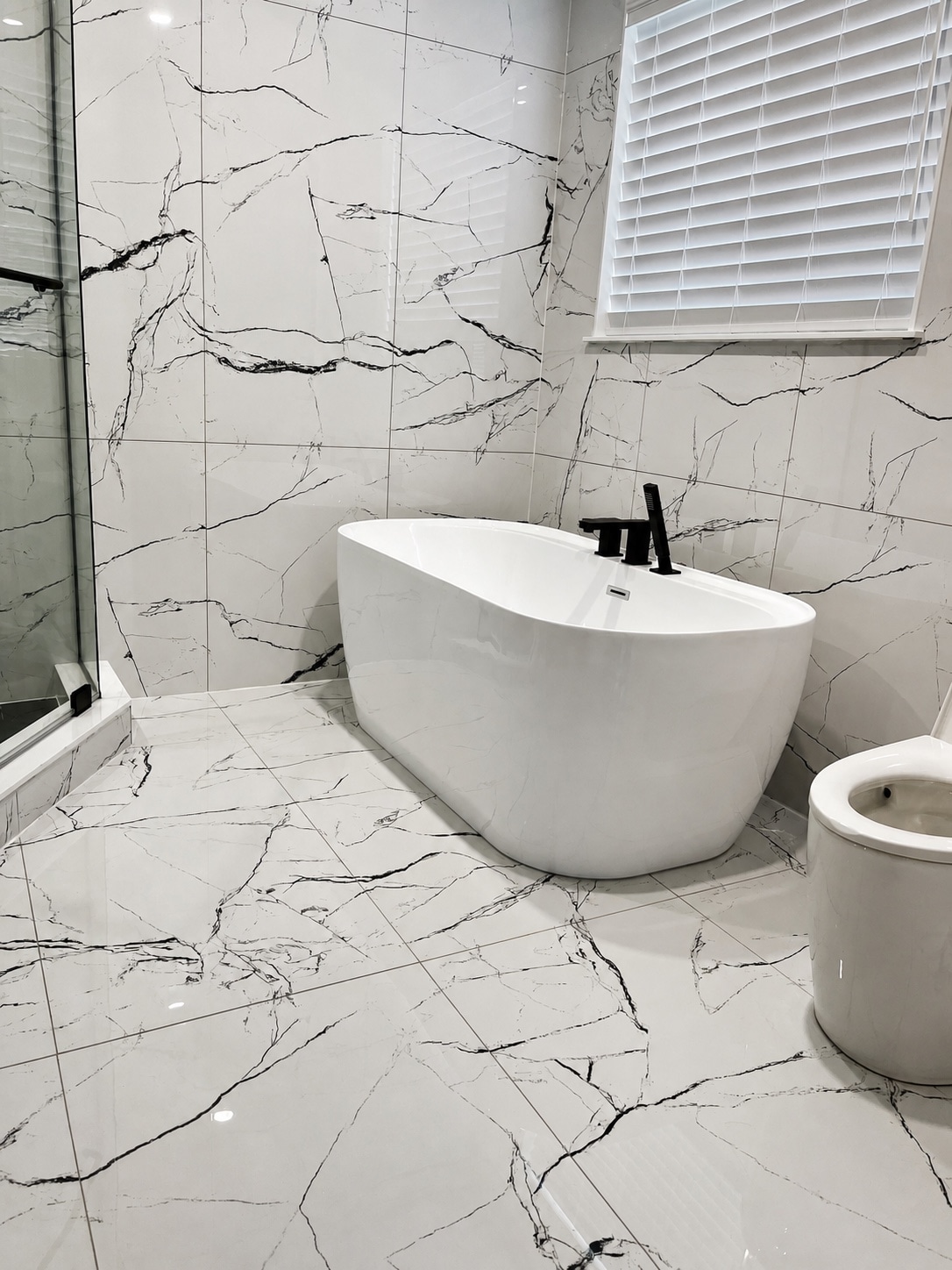 Freestanding tub with continuous marble-look tile