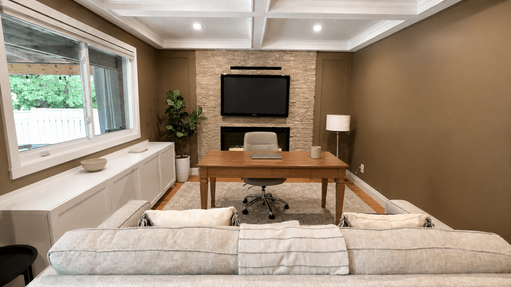Front view of the finished office with a professional desk, stone feature wall and detailed coffered ceiling